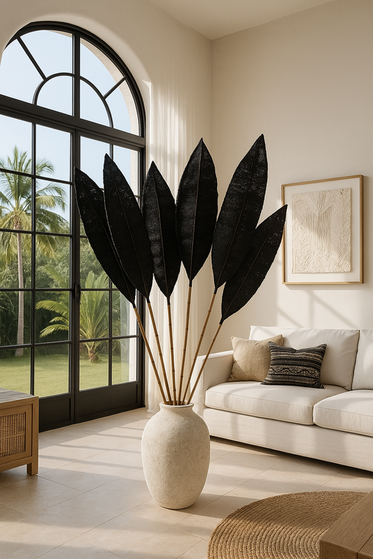A decorative palm leaf accent with bamboo stem in a natural color, placed in a vase on a floor inside a room with tropical decor.