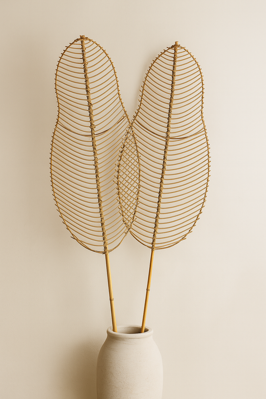 Decorative wire leaf sculpture in a white vase against a beige background