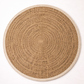 Round woven placemat with concentric circle pattern on a white background
