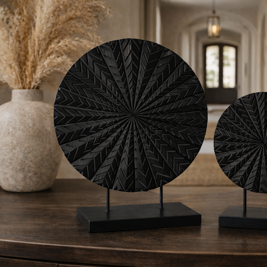 Two black decorative items on stands in a room with decor elements.
