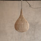 Woven pendant light hanging against a textured wall.