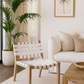 Living room with a woven chair, white sofa, and palm plant.