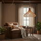 Cozy living room with a brown armchair, woven lamp, and plants.
