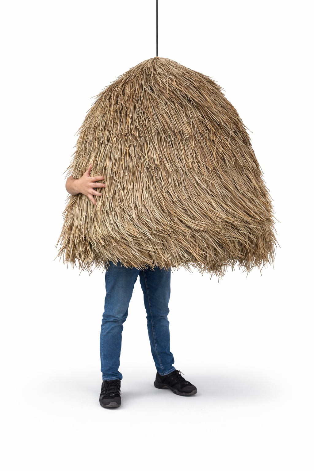 Person holding a large woven straw hat against a white background