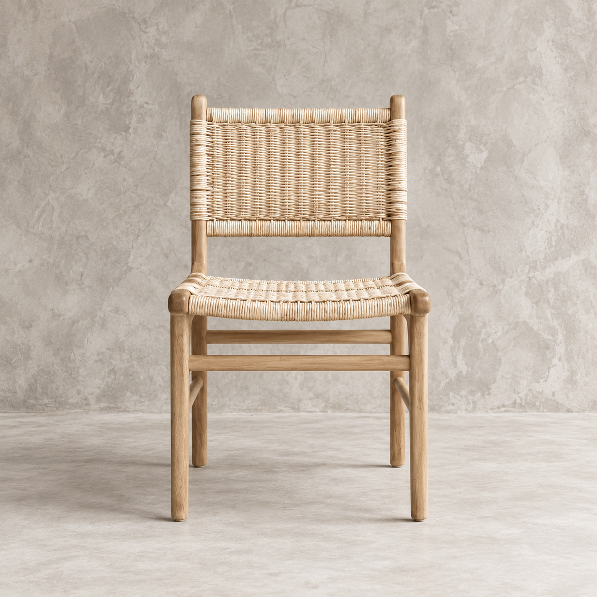 A light natural wood dining chair with a woven rattan or rope seat and back, shown against a textured concrete wall and floor.