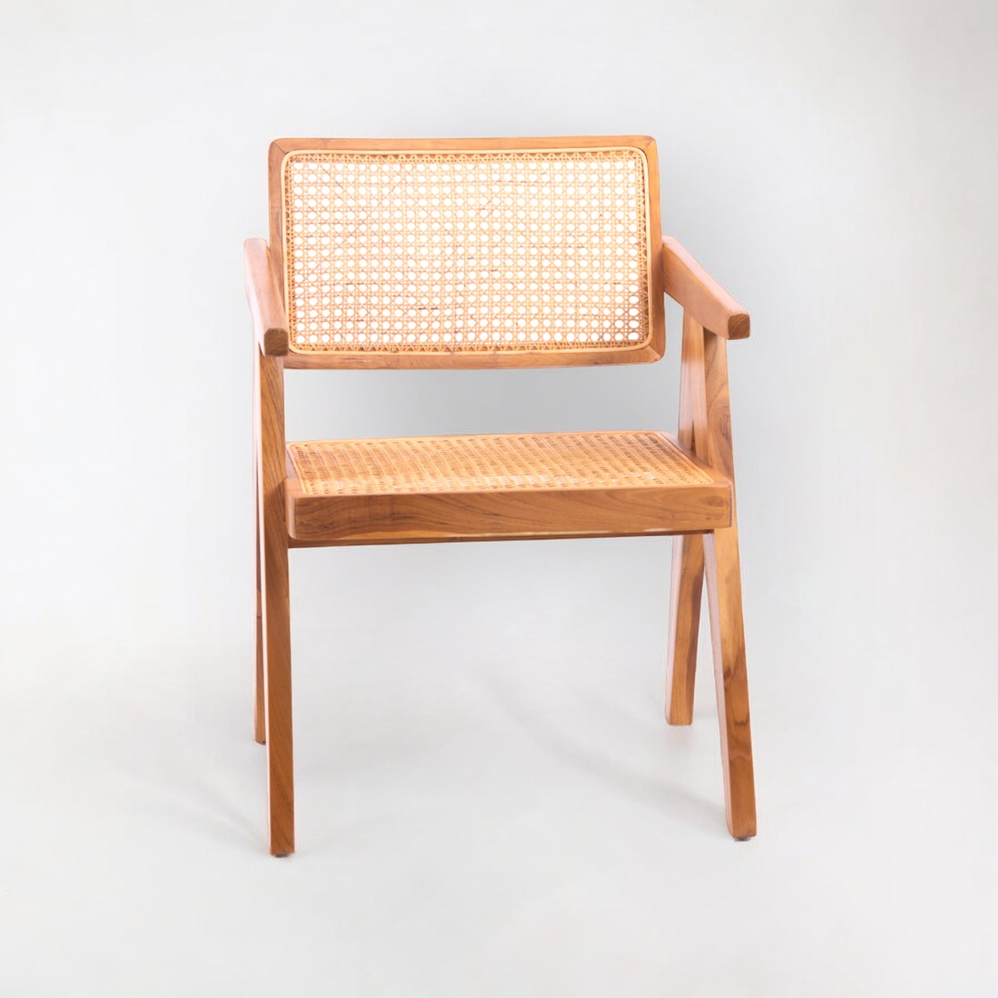 A rattan chair with handwoven rattan backrest and seat, teak wood frame, and armrests.