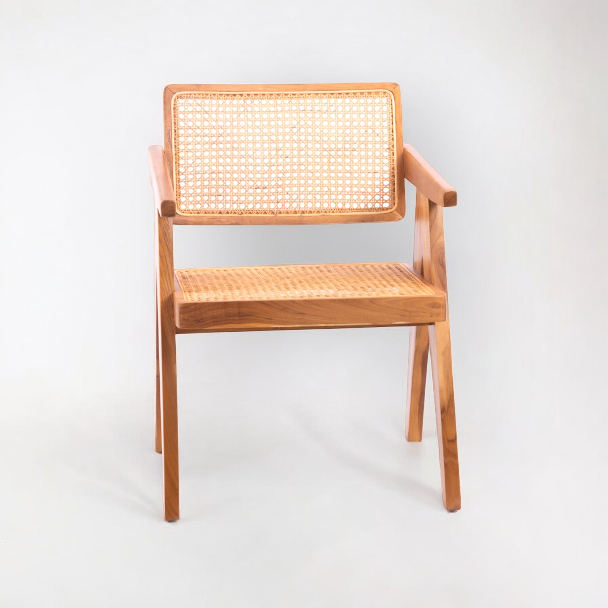 A rattan chair with handwoven rattan backrest and seat, teak wood frame, and armrests.