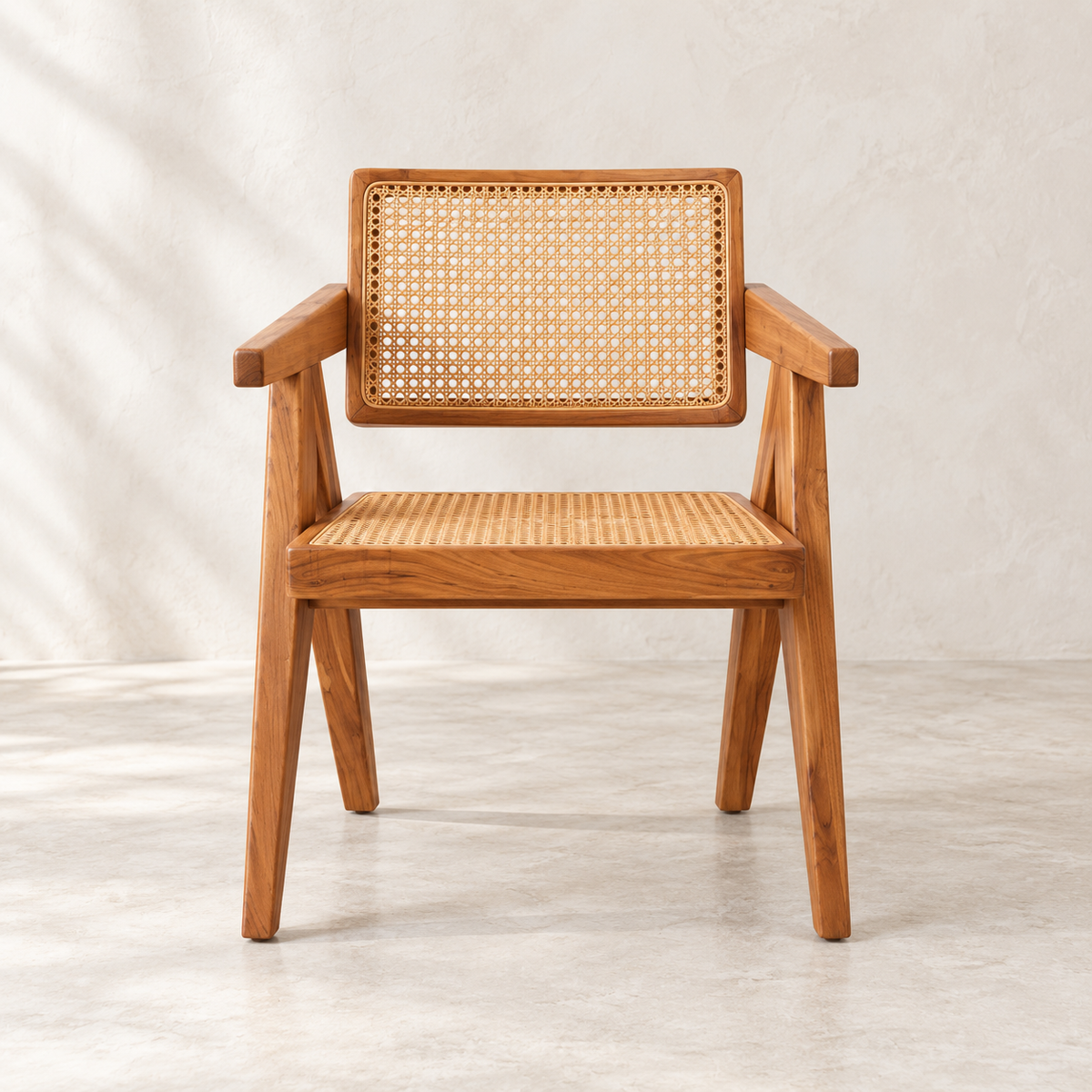 A mid-century modern wooden armchair with a woven cane backrest and seat, shown against a neutral textured beige wall and floor.
