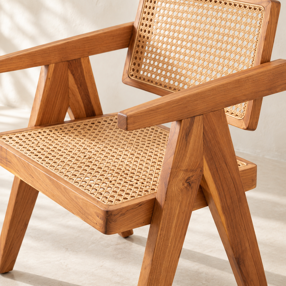 A wooden armchair with a woven cane backrest and seat, shown in a close-up studio-style shot against a light neutral background.