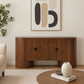 Wooden sideboard with abstract art above it in a living room setting.
