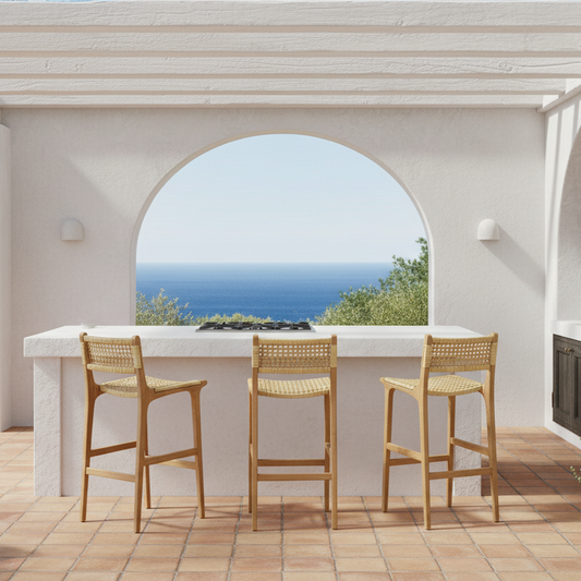 Outdoor kitchen area with a bar counter and stools, overlooking a scenic view.